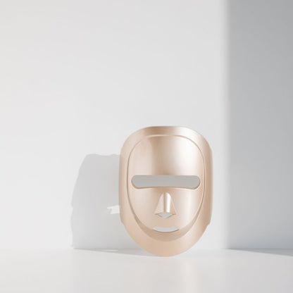 Gold mask-shaped device on a white background