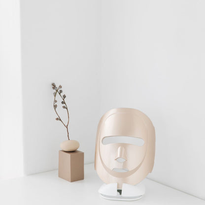 Modern face-shaped lamp on a white surface with a minimalistic background