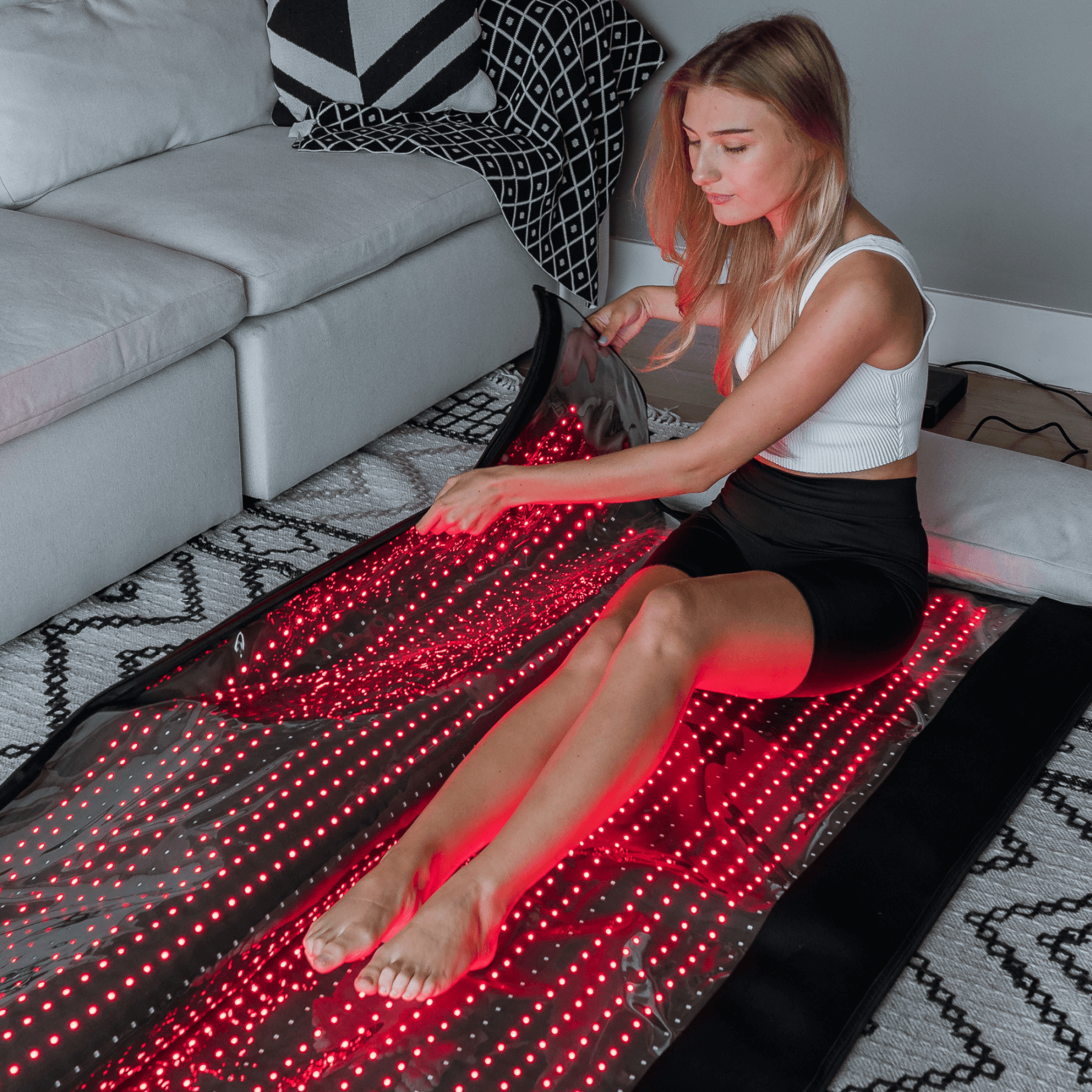Woman using a LED mat in a living room setting