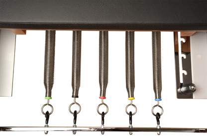 Set of fishing rigs with springs and hooks on a metal rod against a white background