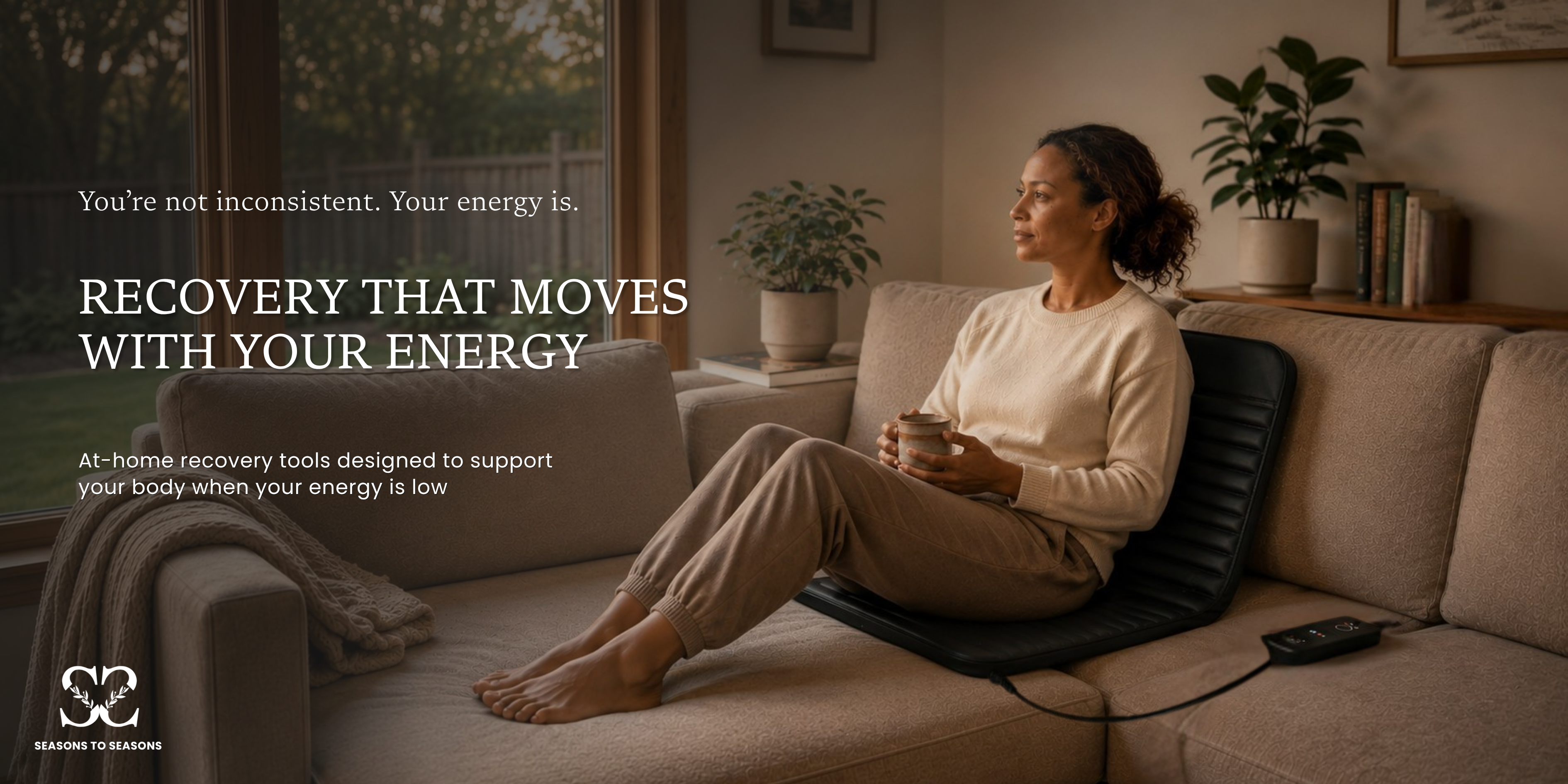 Woman relaxing on HEALiX Revive Mini PEMF recovery mat in a warm home living room environment supporting low energy recovery and everyday wellness routines